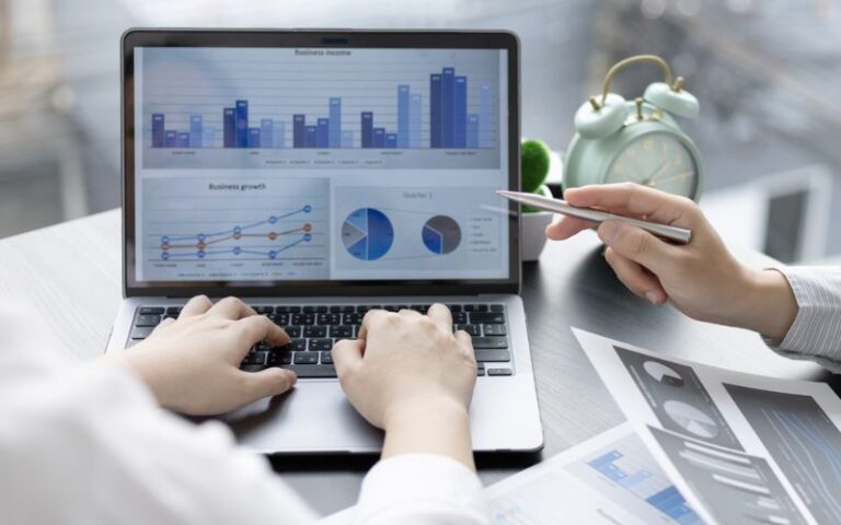 Marketing professionals analyzing charts and graphs on a laptop to create compelling visual content for successful affiliate campaigns.